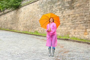 Beautiful young woman with umbrella outdoors