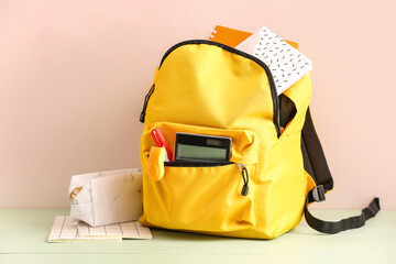 School backpack with stationery and pencil case on table