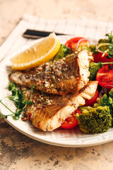 Plate with tasty baked cod fillet and vegetables on color background, closeup