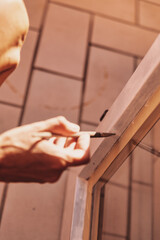 woman hands sandpaper and repair windows and wooden frames