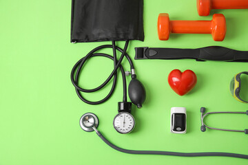 Composition with pulse oximeter, sphygmomanometer and stethoscope on color background