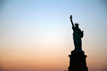 The silhouette of Lady Liberty during an epic summer sunset