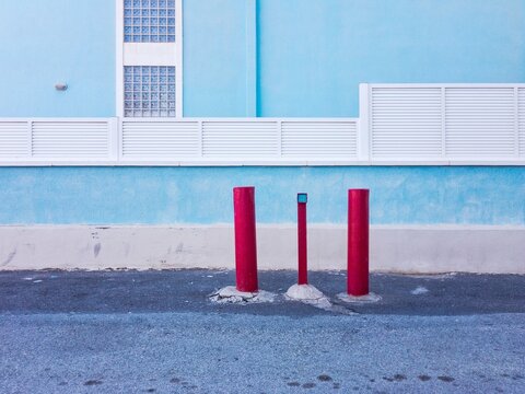 Multicolored Wall And Red Posts Against Building