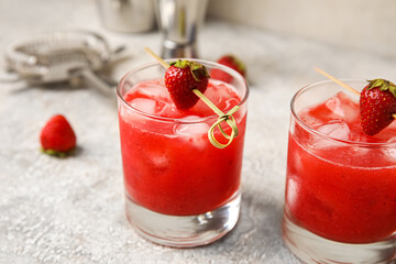 Glasses of tasty strawberry margarita on light background