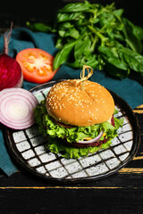 Plate with tasty vegetarian burger on dark wooden background