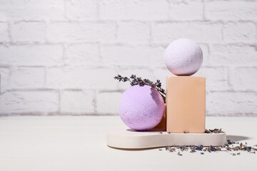 Composition with bath bombs and lavender flowers near light brick wall