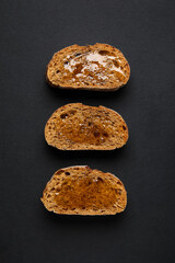 Tasty toasted bread with honey on black background