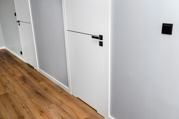 A white door with a ventilation undercut with a matte black handle and a black line in the middle...