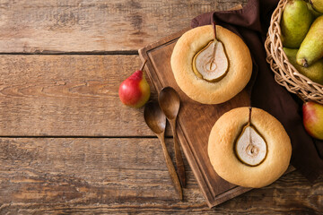Board with tasty pear pot pies and fresh fruits on wooden background
