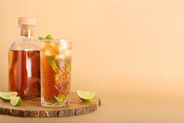 Board with bottle and glass of tasty Long Island iced tea on color background