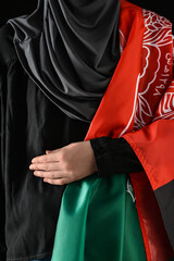 Fototapeta premium Woman with flag of Afghanistan on dark background
