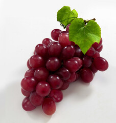 Cacho de uva rosada com folha da fruta em fundo branco para recorte.