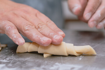 hands kneading dough medialunas