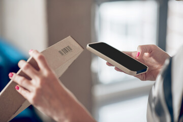 Internet shop worker scanning information on the product package