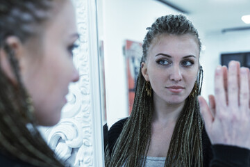 young girl loves her own image in the mirror