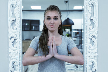 yoga namaste salutation by young  woman with dreadlocks