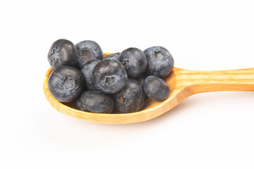 fresh blueberries lie in a wooden spoon on a white background. vitamin organic food
