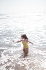 child playing in the water at the beach