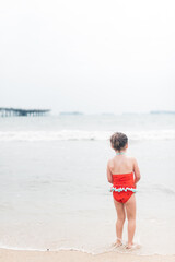 Girl looking at the ocean on the beach