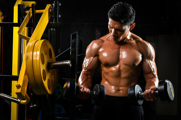 Fototapeta na wymiar Images of Asian men with beautiful muscles lifting weights at the gym.