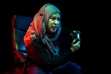 Asian Muslim mothers playing console games with funny faces.