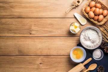 Baking utensils and cooking ingredients for cake bakery include flour, butter, sugar, eggs, and tools on the table, top view with copy space.