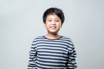 Portrait of a cute Asian boy smiling with happiness, on white background.