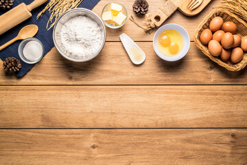 Baking utensils and cooking ingredients for cake bakery include flour, butter, sugar, eggs, and tools on the table, top view with copy space.