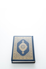 Islamic concept - The Holy Al Quran with written Arabic calligraphy meaning of Al Quran, Arabic word translation: The Holy Al Quran (holy book of Muslim), on white background, with copy space.