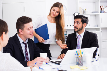 Group of confident business colleagues planning work at joint meeting