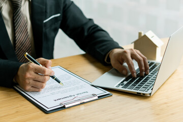 Businessman or home sales representative works with contract documents and calculator with laptop...