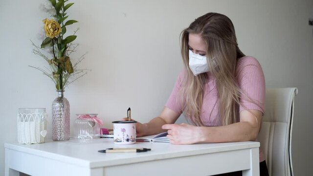 A young girl writes a letter to her lover in her apartment. Distance relationship.