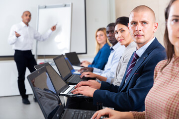 Side view of a group of businessmen undergoing training under the guidance of a teacher