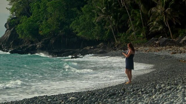 Filipino woman on the beach taking selfies on her vacation. Looc Beach in Surigao Philippines.