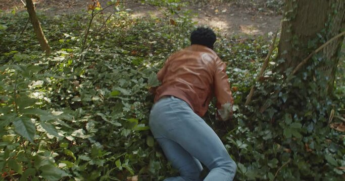 scared Man crawling away and being dragged through foliage - point of view horror scene