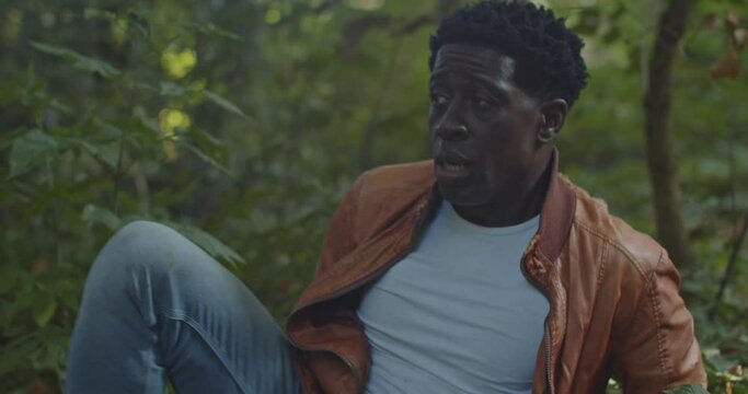 Scared man crawling away and being dragged of by invisible attacker