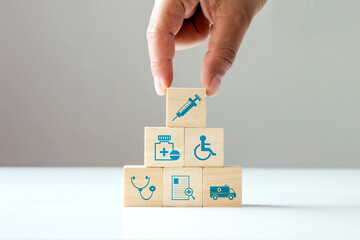 Stacking wooden blocks, human hand health care icons and medical icons. The concept of choosing health insurance rights when sick