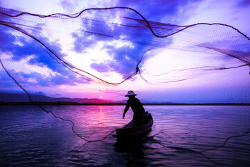 Silhouetted of fisherman catching fish in the lake.