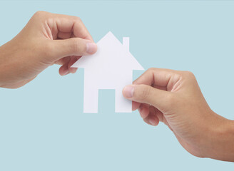 Hands holding paper house, family home  protecting insurance concept