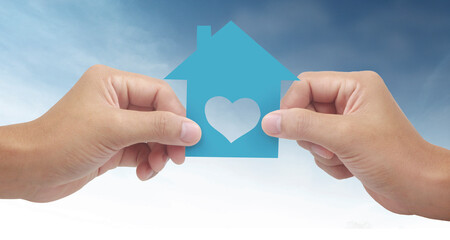 Hands holding paper house, family home  protecting insurance concept