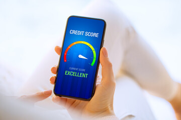 Woman looking at her credit score test on mobile phone showing excellent score
