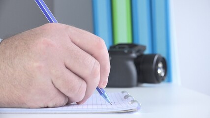 Close Up Image with a Businessman at Workplace Taking Notes