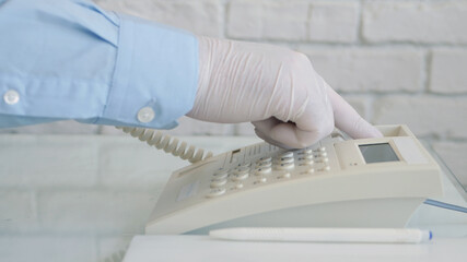 Image with Businessman Hands Wearing Protective Gloves Using Telephone