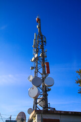 telecommunications tower of different mobile phone, radio and television operators with masts and microwave radio link antennas, 4g and deployment of 5g generation in cities and rural areas