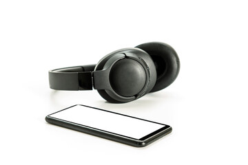 Obraz na płótnie Canvas headphones with Bluetooth technology on white background, with black phone paired for music lovers