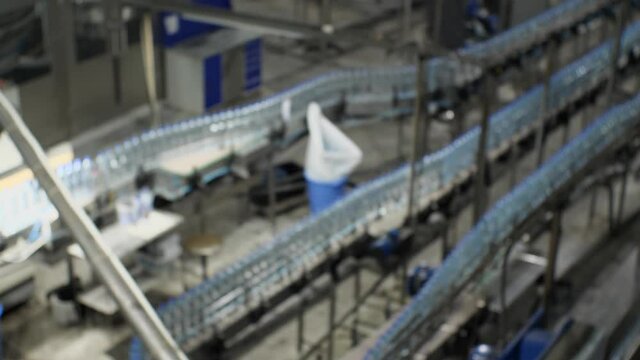 Blurred video automatic conveyor line with plastic bottles at the plant for the production of mineral water and soft drinks