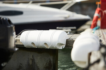 Long pier white fenders for a boat and dockside for protection. Maritime fenders