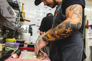 male cooks preparing sushi in the restaurant kitchen.