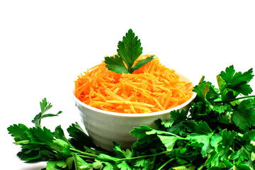 Grated carrot in a white bowl, fresh green parsley isolated on a white background. Set of vegetables for cooking borscht. Diet. Selective focus. Flat lay, top view.