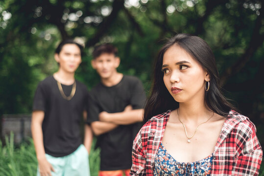 A Young Woman Walking By Herself Is Worried About Two Rude Men Catcalling And From Behind. Possible Stalkers Following Her. Street Harassment.